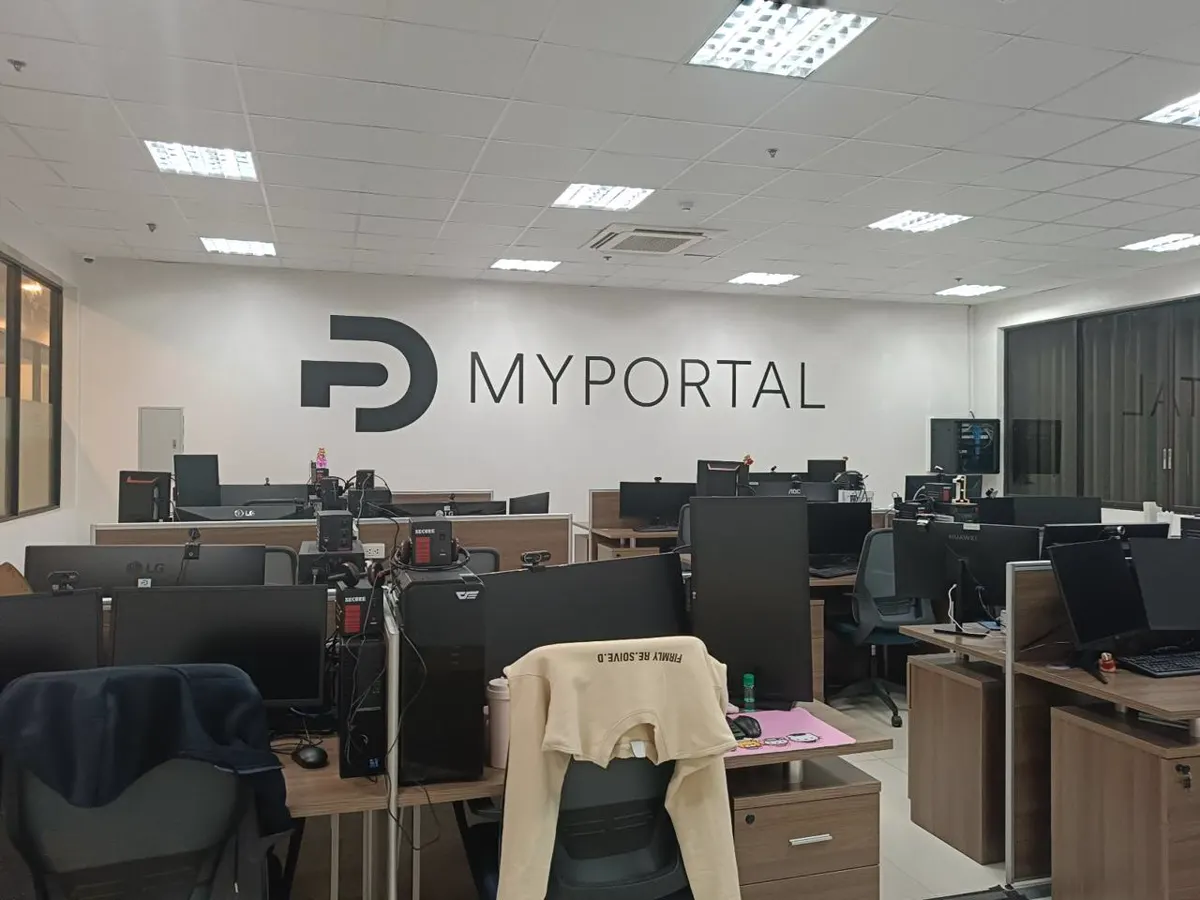 The MyPortal office floor, rows of desks under the MyPortal wall sign