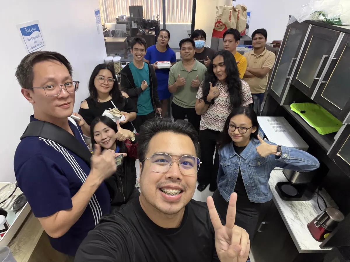 Team members giving a thumbs up in the office pantry